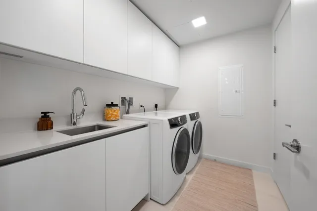 a utility room with sink dryer and washer