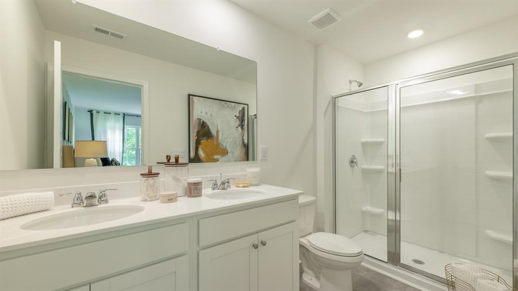 2836 Georgia Aster Way Northwest Atlanta, GA 30341 - Photo 18 of 28 a bathroom with a shower sink vanity mirror and toilet