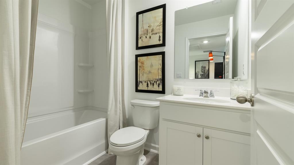 2836 Georgia Aster Way Northwest Atlanta, GA 30341 - Photo 26 of 28 a bathroom with a toilet a sink a mirror and a bathtub