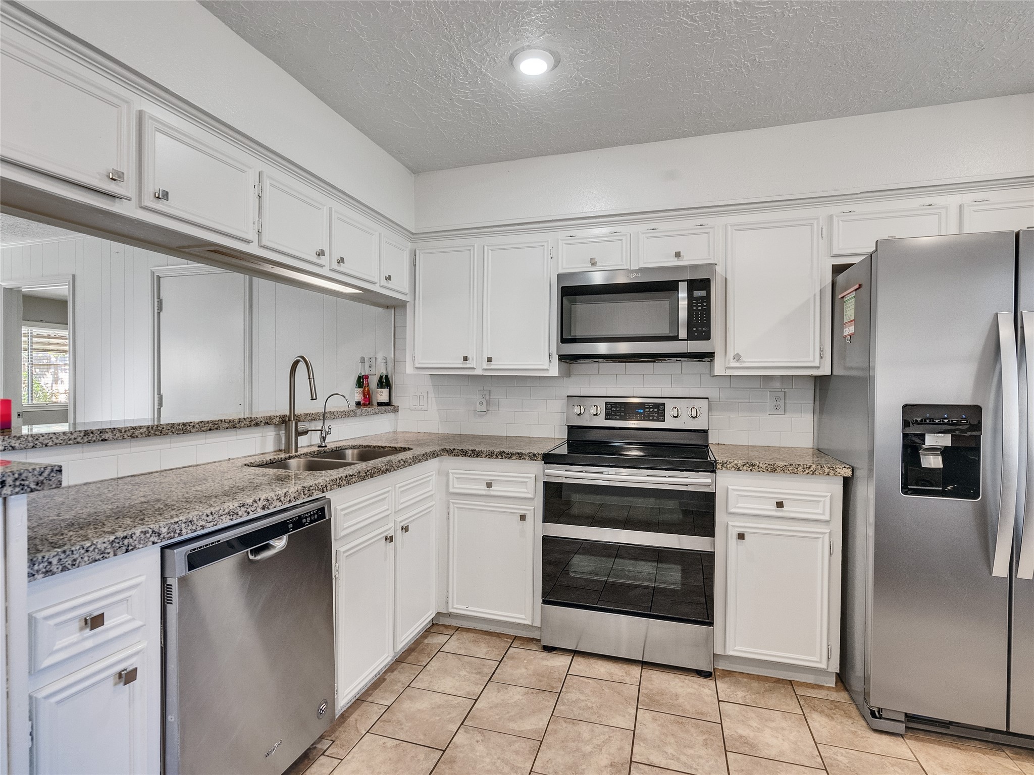 2201 Georgetown Street Katy, TX 77493 - Photo 11 of 20 a kitchen with granite countertop a sink stainless steel appliances and white cabinets