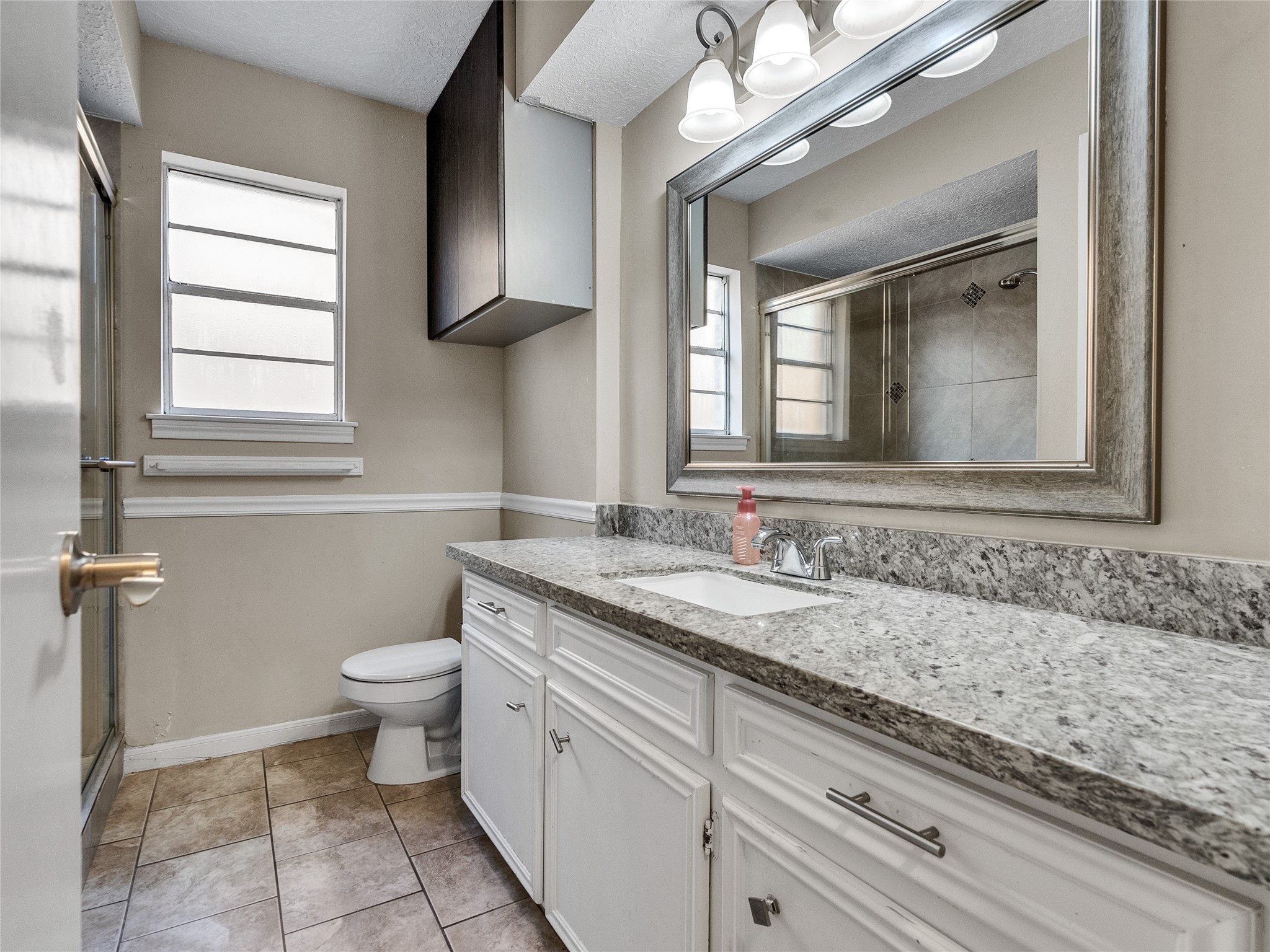 2201 Georgetown Street Katy, TX 77493 - Photo 18 of 20 a bathroom with a granite countertop sink a toilet and a mirror