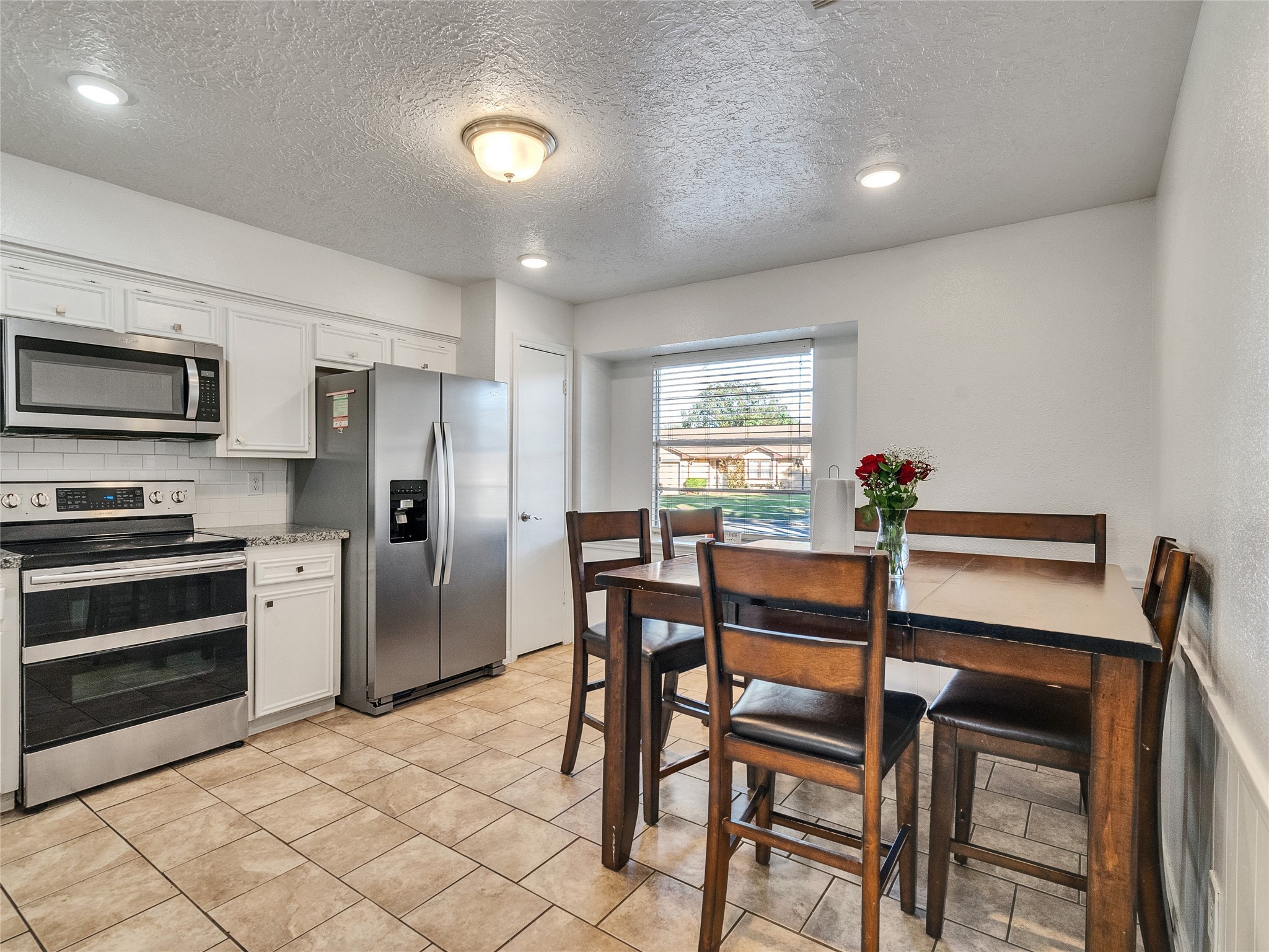 2201 Georgetown Street Katy, TX 77493 - Photo 9 of 20 a kitchen with a table chairs refrigerator and microwave