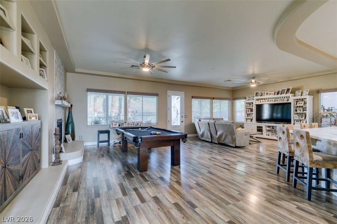 7524 Midnight Rambler Street Las Vegas, NV 89149 - Photo 6 of 51 A spacious common area with beautiful flooring, a cozy fireplace, and ample natural light from surrounding windows.