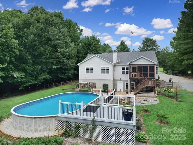 a white house with a large pool and lawn chairs