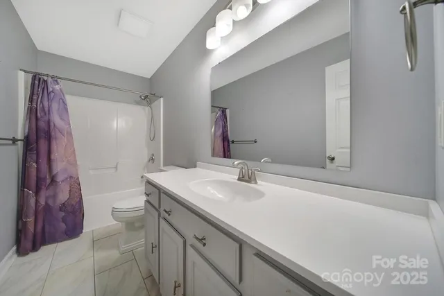 a bathroom with a sink vanity granite and toilet