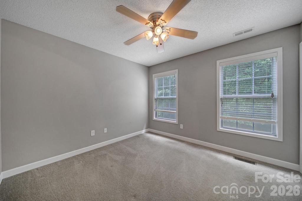 4394 Mountain Creek Road Iron Station, NC 28080 - Photo 16 of 45 an empty room with windows and fan