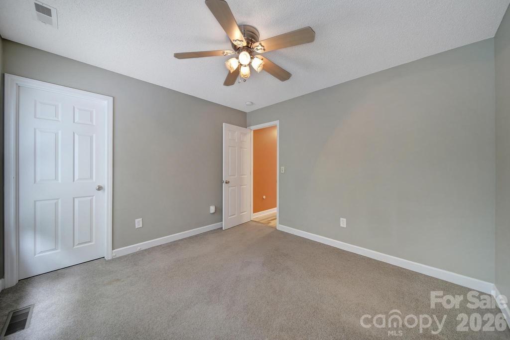 4394 Mountain Creek Road Iron Station, NC 28080 - Photo 17 of 45 an empty room with closet and a chandelier fan