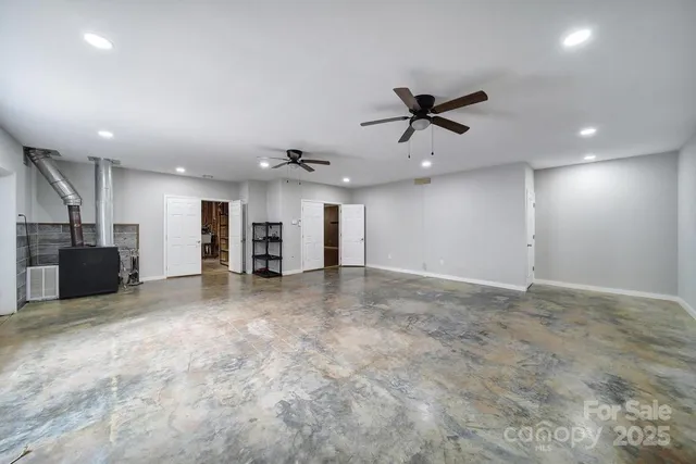 an empty room with a ceiling fan and window