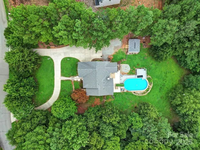 an aerial view of a house with outdoor space pool seating area and yard