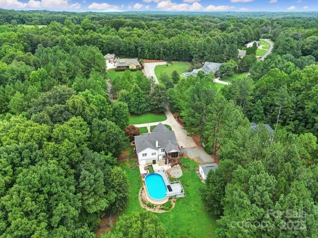 an aerial view of a house with a yard basket ball court and outdoor seating