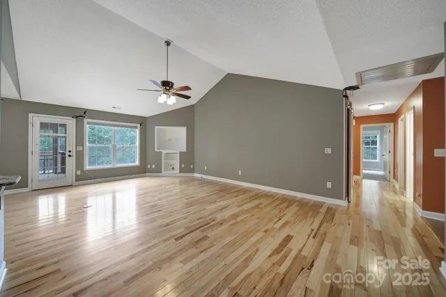 a view of a room with wooden floor and window