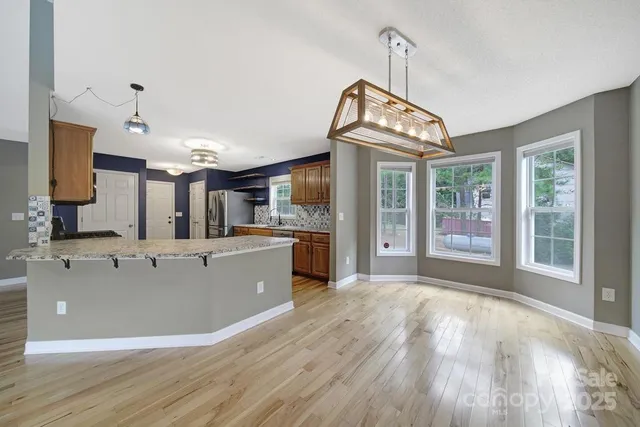 a view of a kitchen with kitchen island a large counter space a sink appliances and cabinets