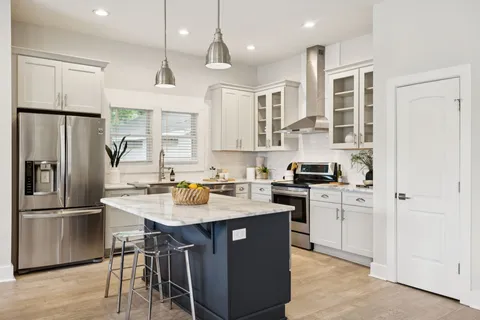 a kitchen with stainless steel appliances granite countertop a stove a sink and a refrigerator