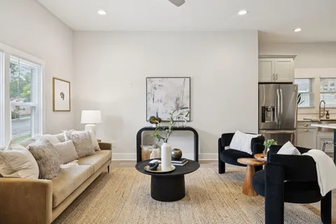 a large kitchen with a table chairs refrigerator and cabinets