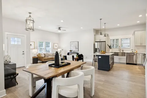 a living room with furniture a fireplace and a chandelier