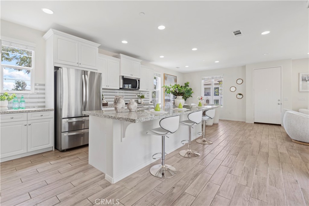 202 Cultivate Irvine, CA 92618 - Photo 14 of 65 a kitchen with stainless steel appliances a refrigerator a stove top oven a sink dishwasher and a refrigerator with wooden floor