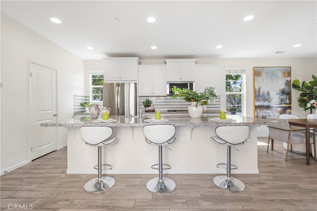 202 Cultivate Irvine, CA 92618 - Photo 10 of 65 a room with lots of table chairs wooden floor and kitchen view