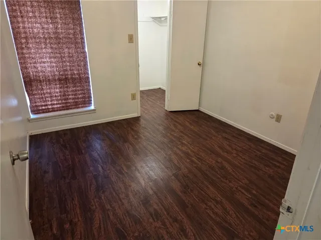 a view of an empty room with wooden floor