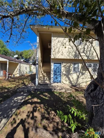 a view of a white house with a yard