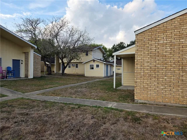a view of backyard with a car parked in it