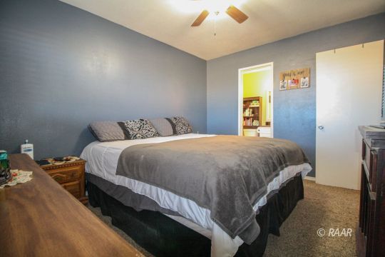 632 South Nevada Street Ridgecrest, CA 93555 - Photo 24 of 29 a spacious bedroom with a bed and a chandelier