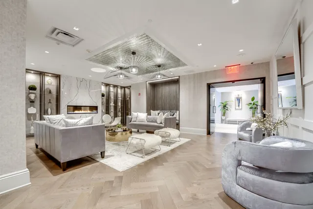 a living room with couches and kitchen view with wooden floor