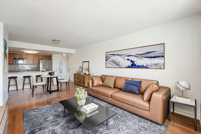 a living room with furniture and a dining table with wooden floor
