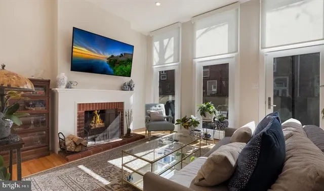 a living room with furniture a flat screen tv and a fireplace