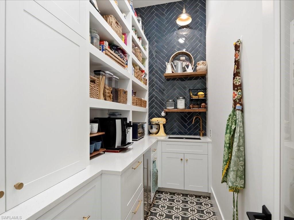 2590 2nd Street Northwest Naples, FL 34120 - Photo 15 of 49 Walking through a charming glass door, you'll never want to leave this adorable & well equipped pantry! Featuring a sink, refrigerator and freezer drawers, extensive pantry & drawer space, and a Scotsman nugget ice maker.