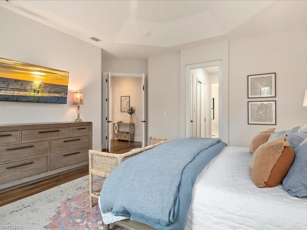 2590 2nd Street Northwest Naples, FL 34120 - Photo 22 of 49 The homeowner's added a pocket door to the ensuite bathroom. On the way, you'll find two walk-in closets with custom PLC closet systems.