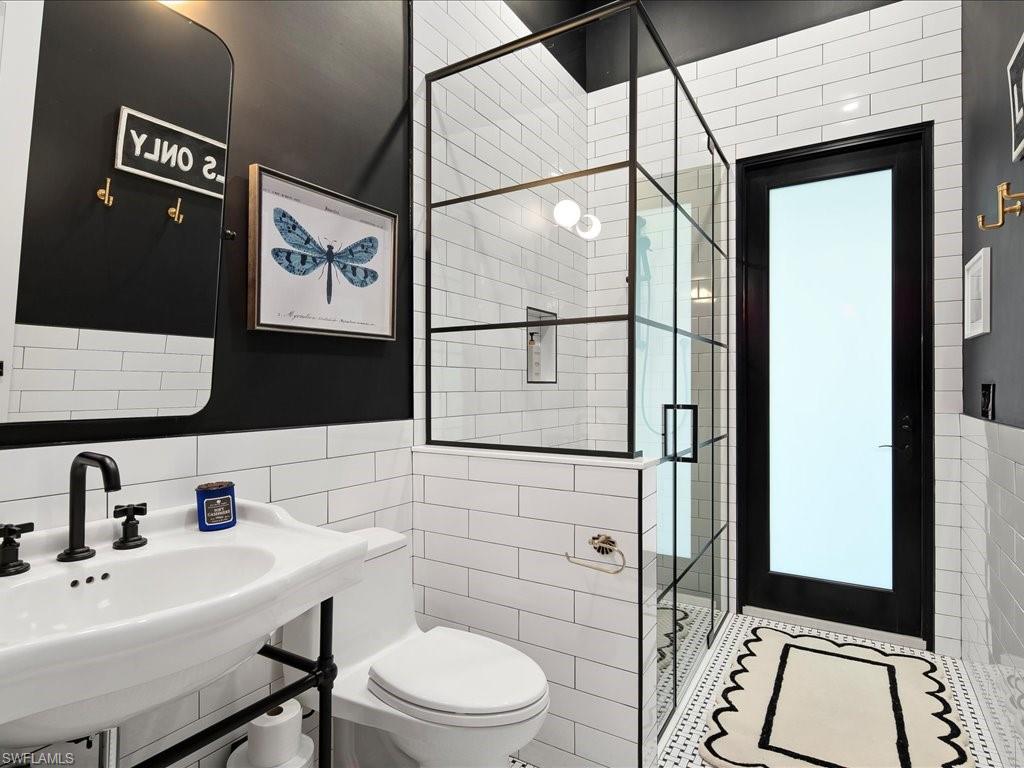 2590 2nd Street Northwest Naples, FL 34120 - Photo 26 of 49 Near the office you'll find the extremely handy full guest/pool bathroom. Completely remodeled in 2024, the walk-in shower is perfect for rinsing off before a swim and even more ideal for bathing your pets!