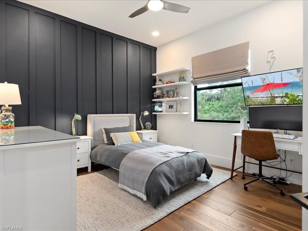 2590 2nd Street Northwest Naples, FL 34120 - Photo 29 of 49 The second bedroom has board & batten walls, a ceiling fan, room darkening shades, and a custom PLC closet system.
