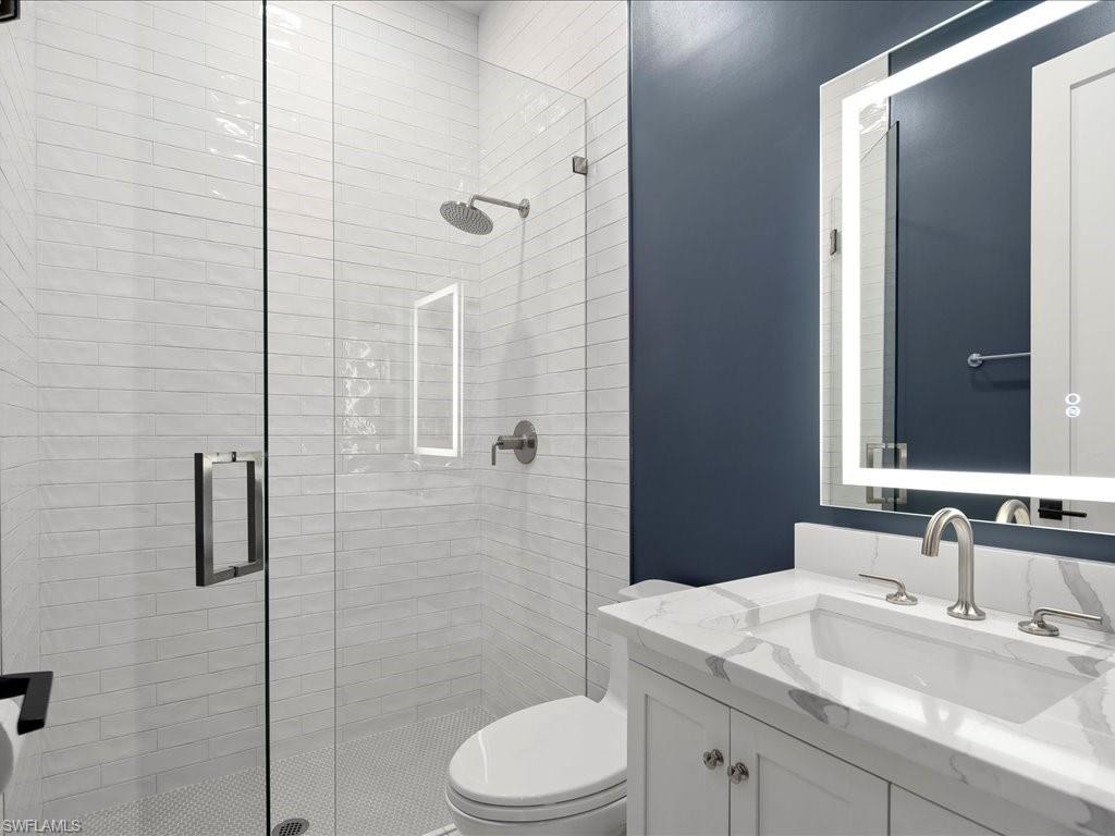2590 2nd Street Northwest Naples, FL 34120 - Photo 35 of 49 The 4th full bathroom in this ensuite was renovated in 2024 and features a walk-in shower with tile surround, built-in storage nook, and lighted mirror.