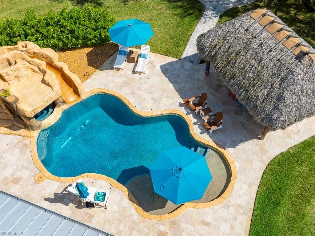 2590 2nd Street Northwest Naples, FL 34120 - Photo 41 of 49 This custom saltwater pool with waterslide, waterfall, grotto-style spa has some really fun water features in addition to a tanning ledge.