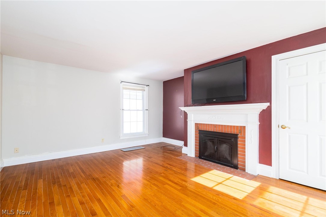 165 9th Street Wellsburg, WV 26070 - Photo 13 of 37 Unfurnished living room featuring light wood finished floors and a brick fireplace