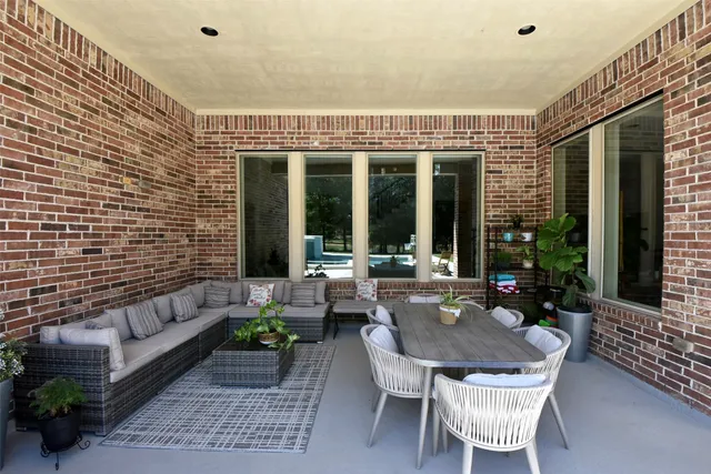 a view of a patio with couches table and chairs and potted plants