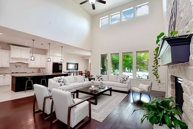 a living room with patio fireplace furniture and a ceiling fan