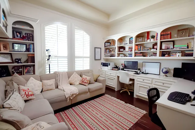 a spacious bedroom with a bed a couch and large window