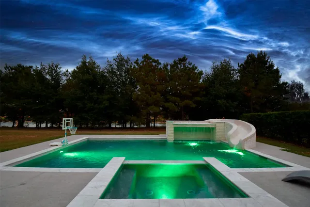 a view of yard with swimming pool and trees