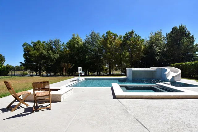 a view of a swimming pool with sitting area and furniture