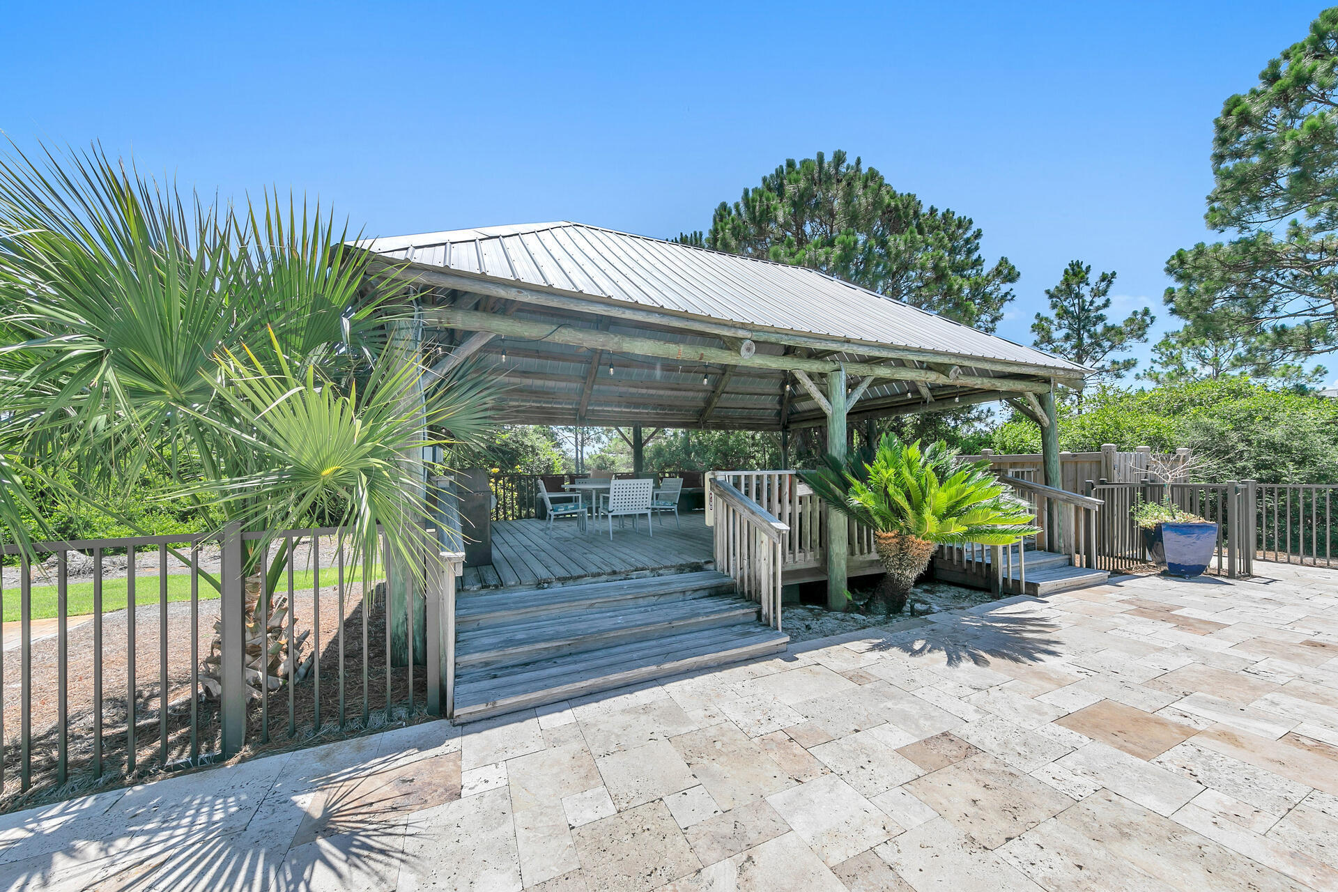 145 Beachfront Trail, Unit 303A Santa Rosa Beach, FL 32459 - Photo 32 of 38 a view of a patio with table and chairs under an umbrella with a small yard