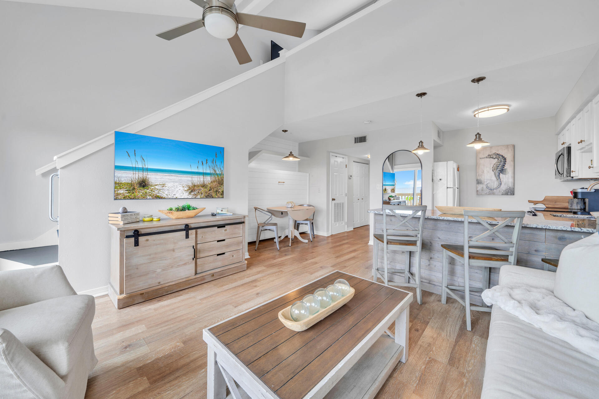 145 Beachfront Trail, Unit 303A Santa Rosa Beach, FL 32459 - Photo 9 of 38 a kitchen with stainless steel appliances kitchen island granite countertop a stove a sink a dining table and chairs with wooden floor