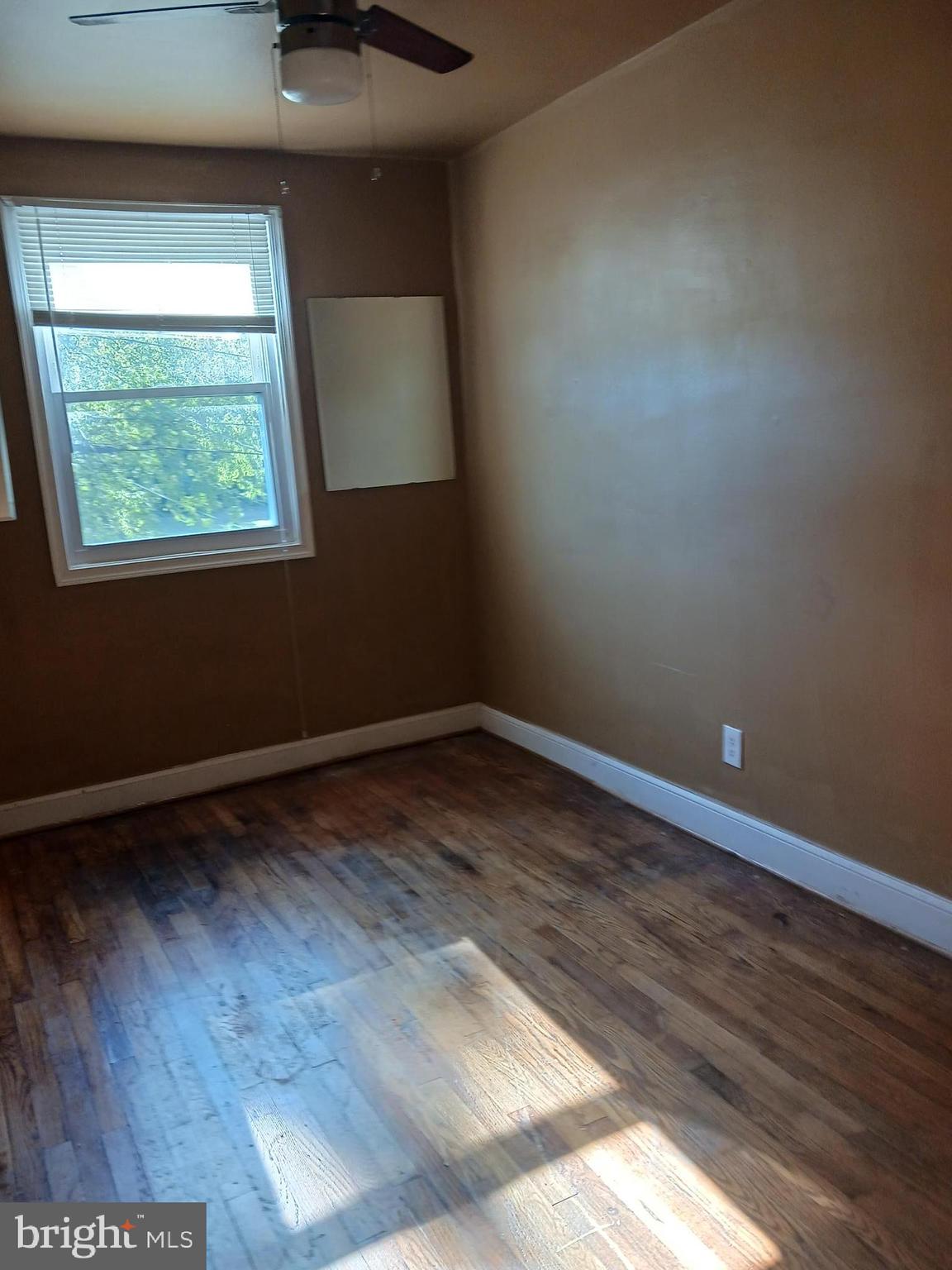 1002 Stamford Road Baltimore, MD 21229 - Photo 12 of 16 an empty room with wooden floor and windows