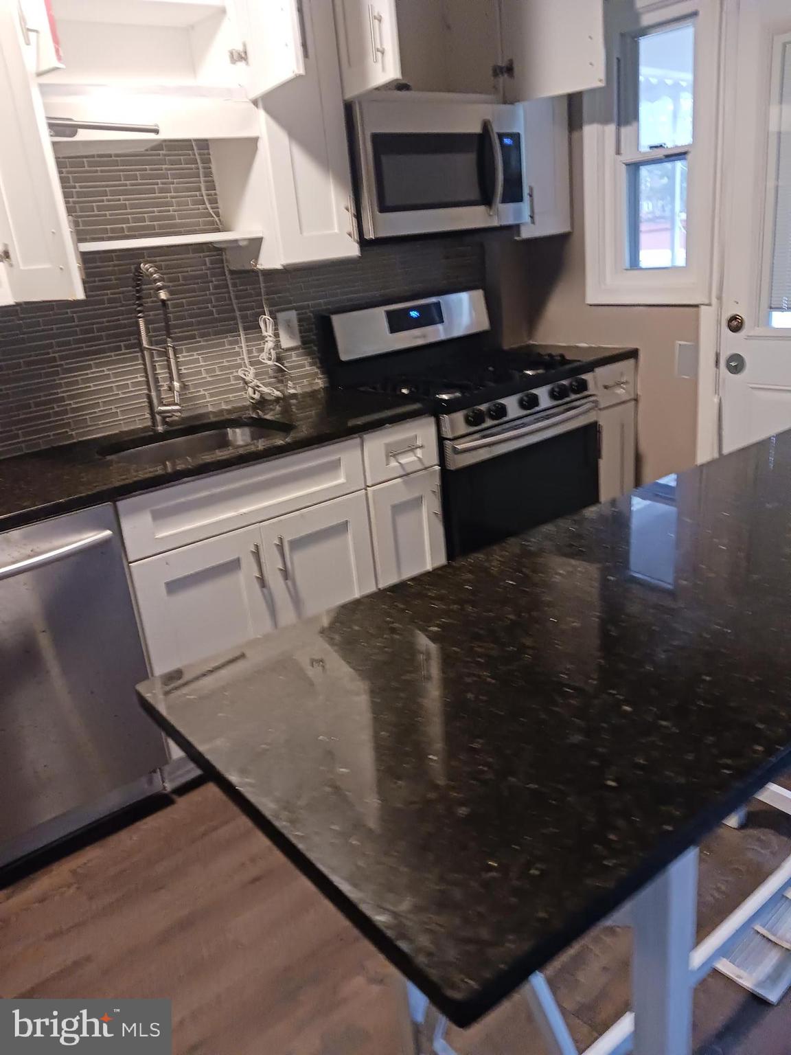 1002 Stamford Road Baltimore, MD 21229 - Photo 3 of 16 a kitchen with granite countertop a stove and a sink