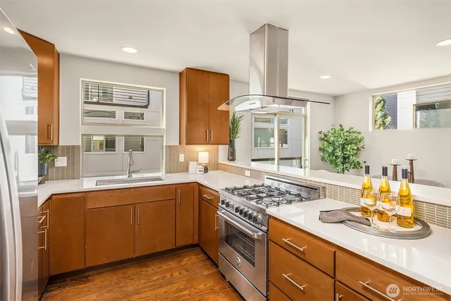 a kitchen with stainless steel appliances granite countertop a sink stove and cabinets