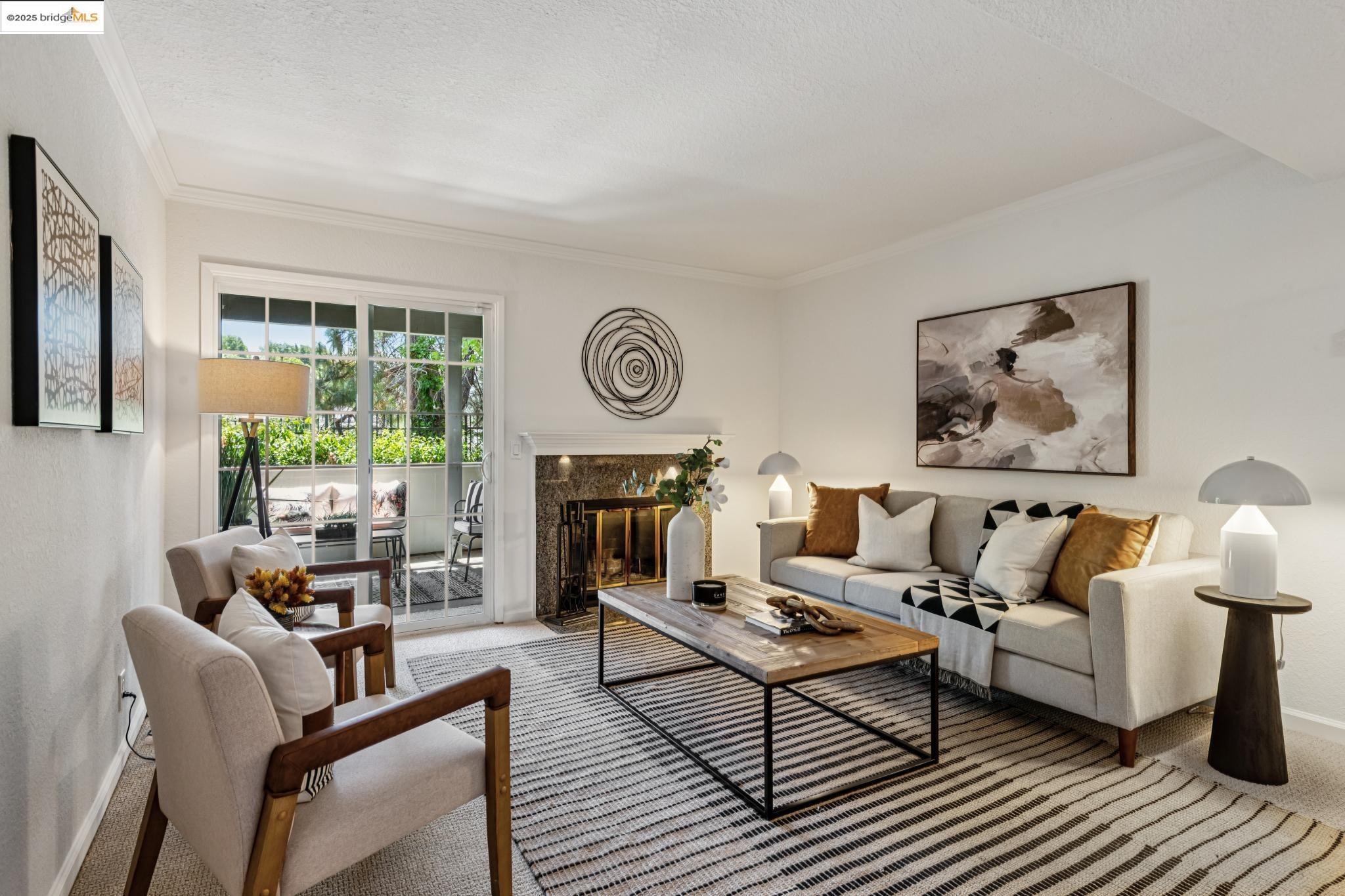 Carpeted living area featuring crown molding, a high end fireplace, and a textured ceiling