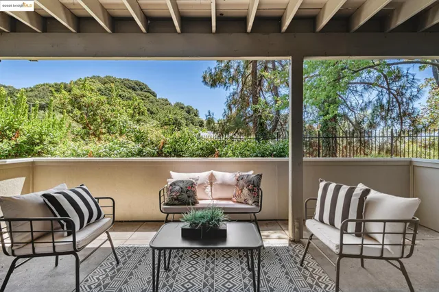 a view of balcony with two chairs and a potted plant