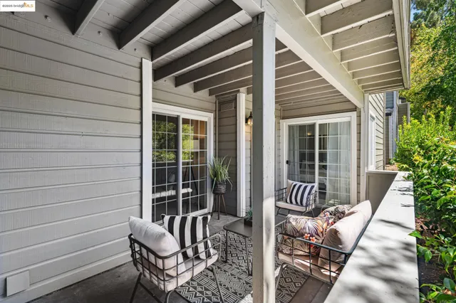a view of a patio with a table and chairs under an umbrella