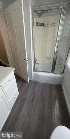 a kitchen with a wooden floor and white cabinets
