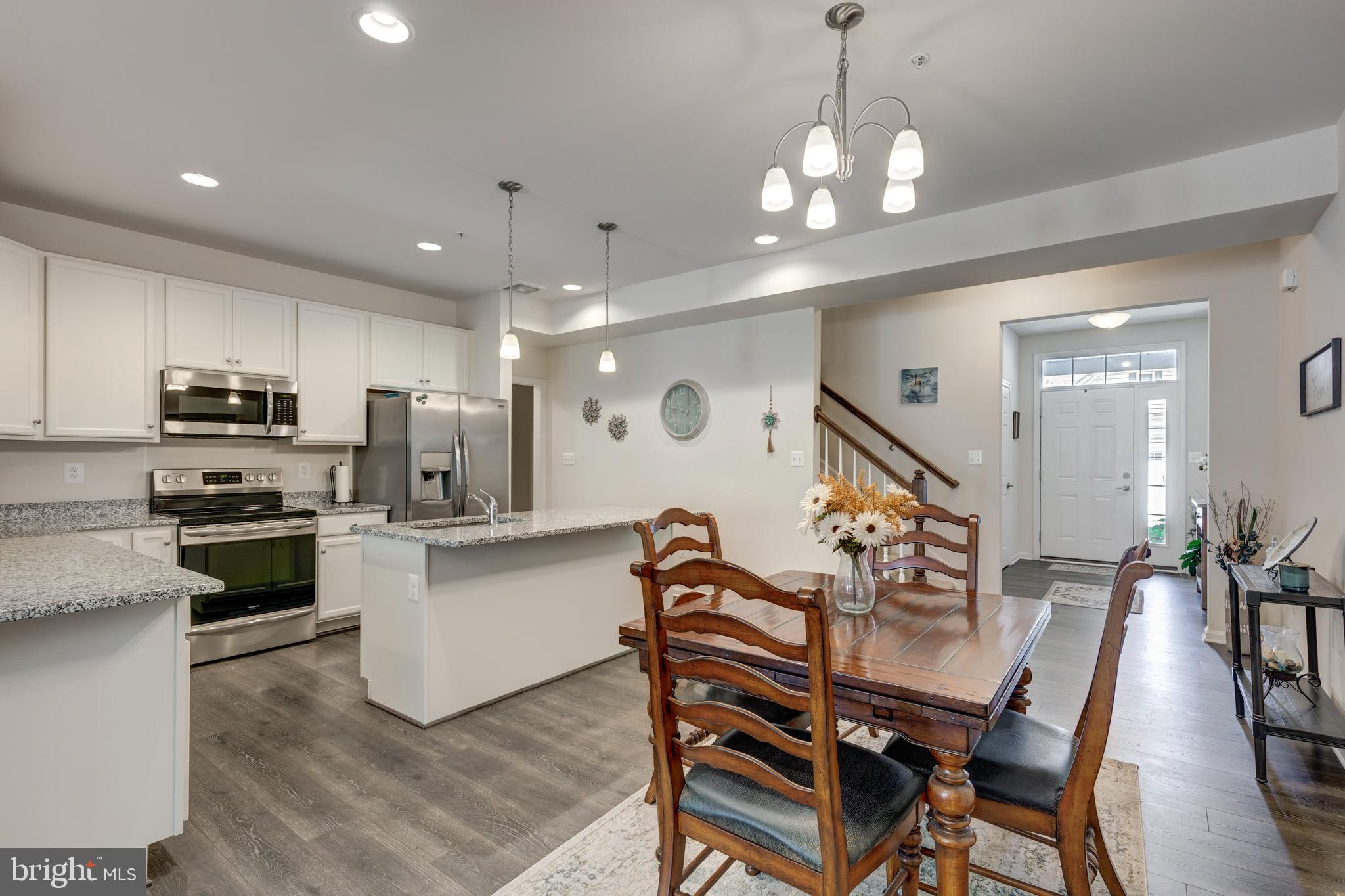 2910 Union Square Road, Unit 34 New Windsor, MD 21776 - Photo 10 of 49 a kitchen with stainless steel appliances a dining table chairs stove and white cabinets